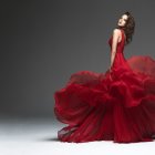 Vintage-style red and green dress woman posing twice with flowing skirt and pin-up hairstyle