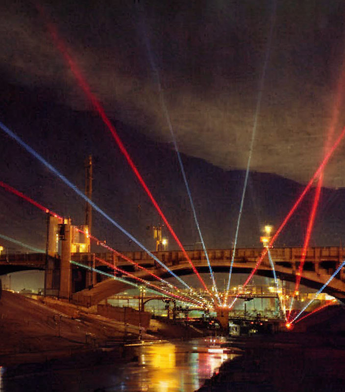 Colorful Light Beams Illuminate Nighttime City Bridge