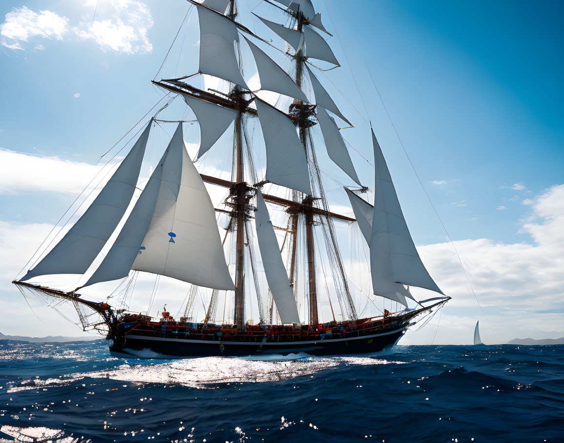 Sailboat with multiple unfurled sails on the sea under clear sky