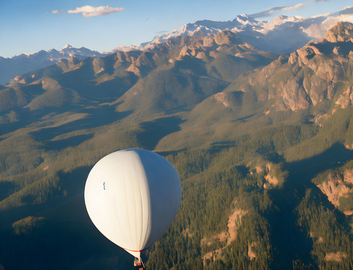 Scenic hot air balloon over forest and mountains at golden hour