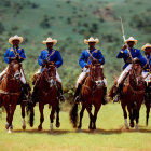 Blue Uniformed Horse Riders on Brown Horses Against Green Hills