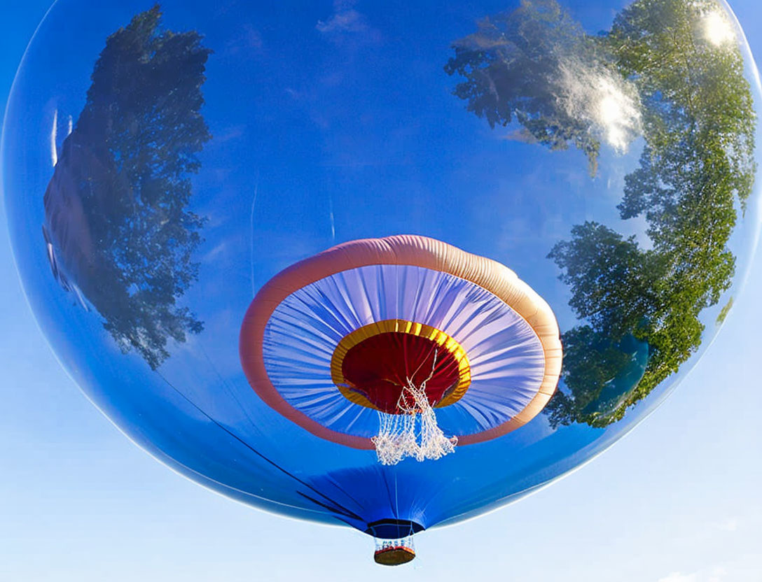 Reflective hot air balloon floating in clear blue sky