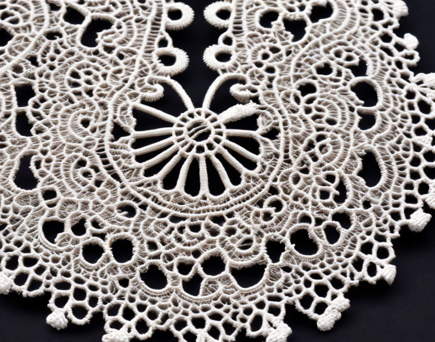 Detailed Beige Lace Doily with Loops and Floral Motifs on Black Background