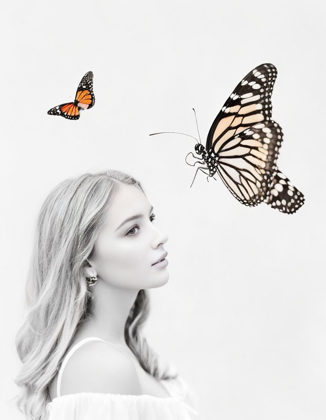 Monochrome photo of young woman with monarch butterflies