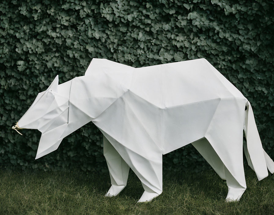 Geometric White Bear Paper Sculpture Against Green Hedge