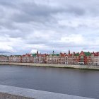 Historical city skyline at dusk with river and pedestrian