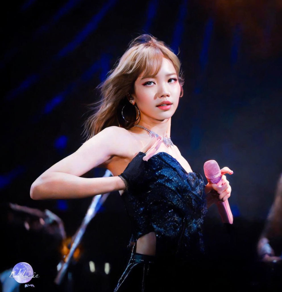 Female performer in sequined top and hoop earrings on stage with microphone