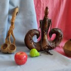 Ornate vases, drapery, red berries, and apples in a still life painting