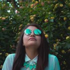 Stylish woman with sunglasses surrounded by colorful wildflowers