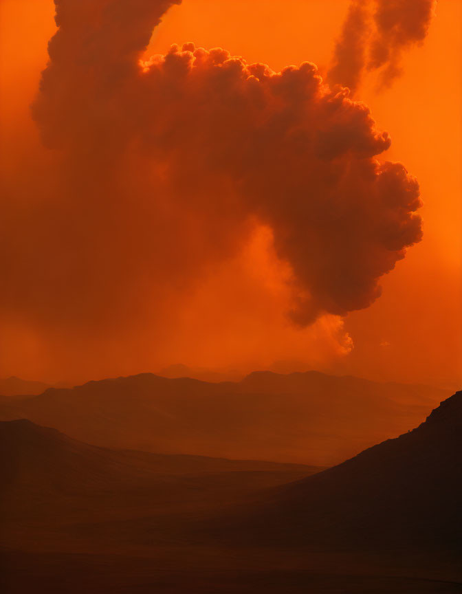 Fiery orange sky with smoke over mountainous landscape