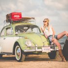 Whimsical artwork: Red-haired woman, vintage car, elephant in misty terrain