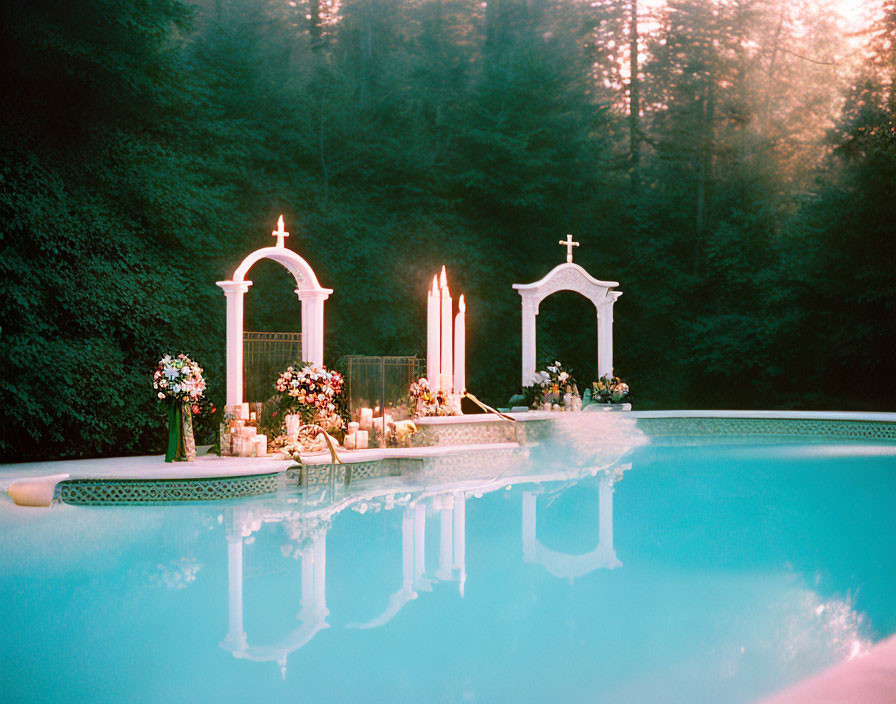 Classical arches and candles surround outdoor pool in serene forest setting