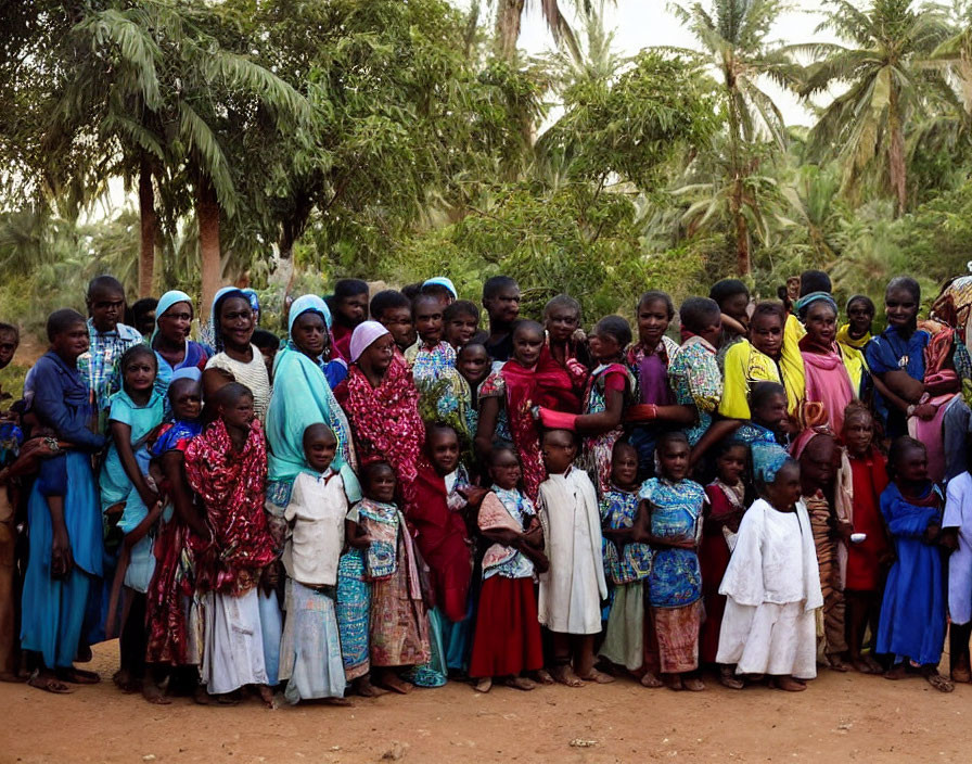 Group of people in colorful traditional attire in lush palm tree setting