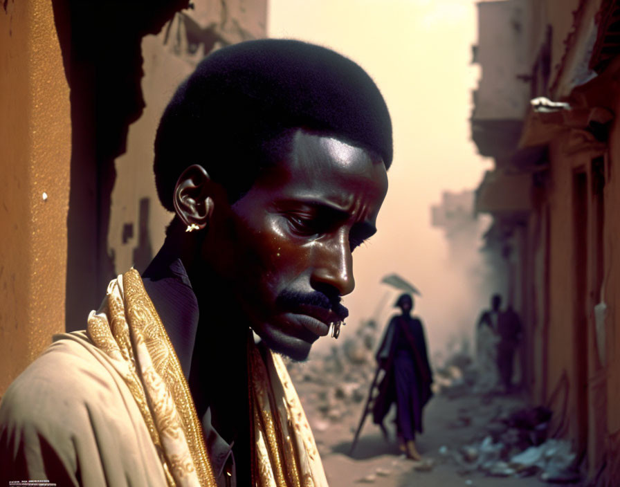 Man with mustache and afro hair in yellow garment on dusty street