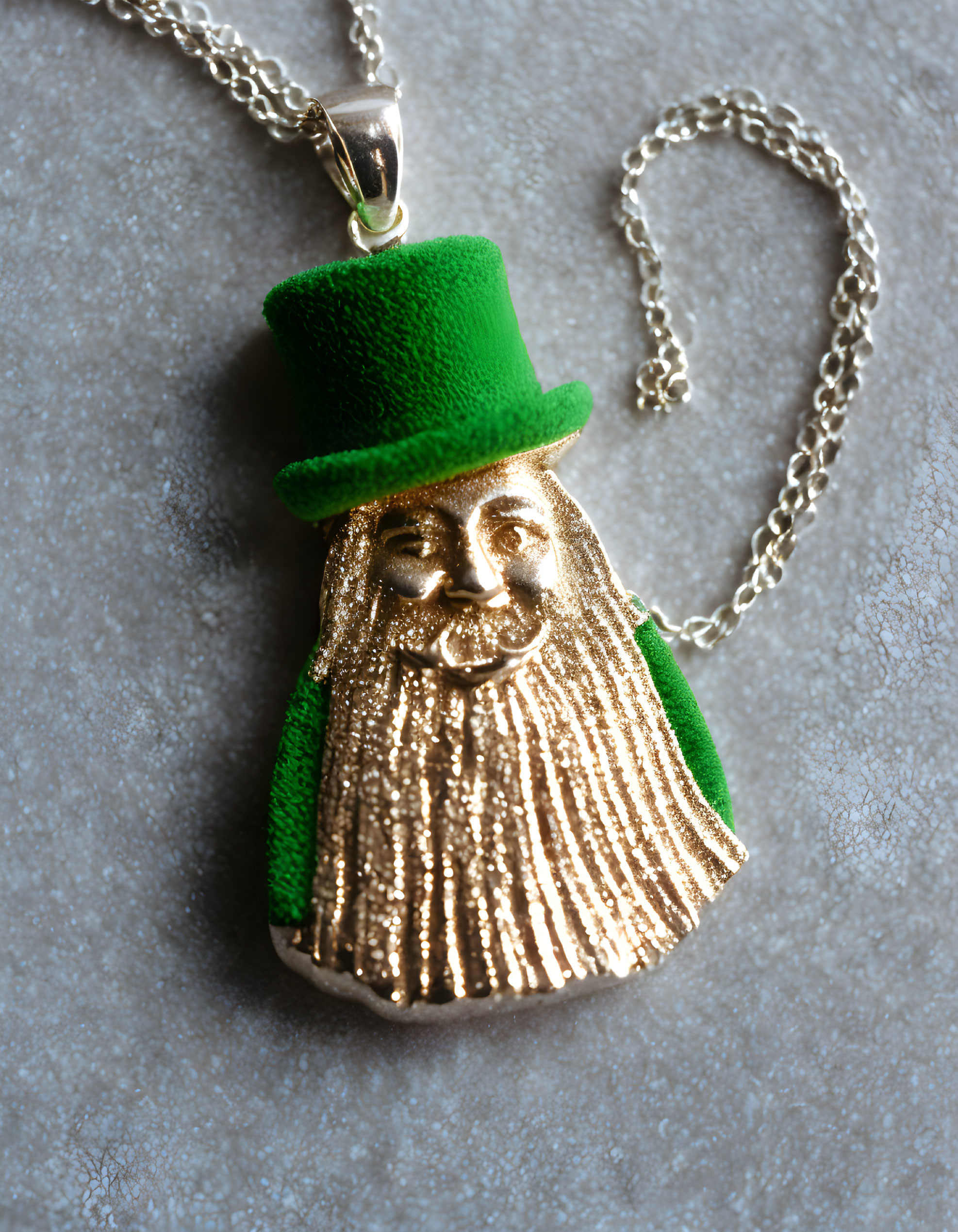 Gold-colored bearded figure pendant on chain with green top hat - gray surface