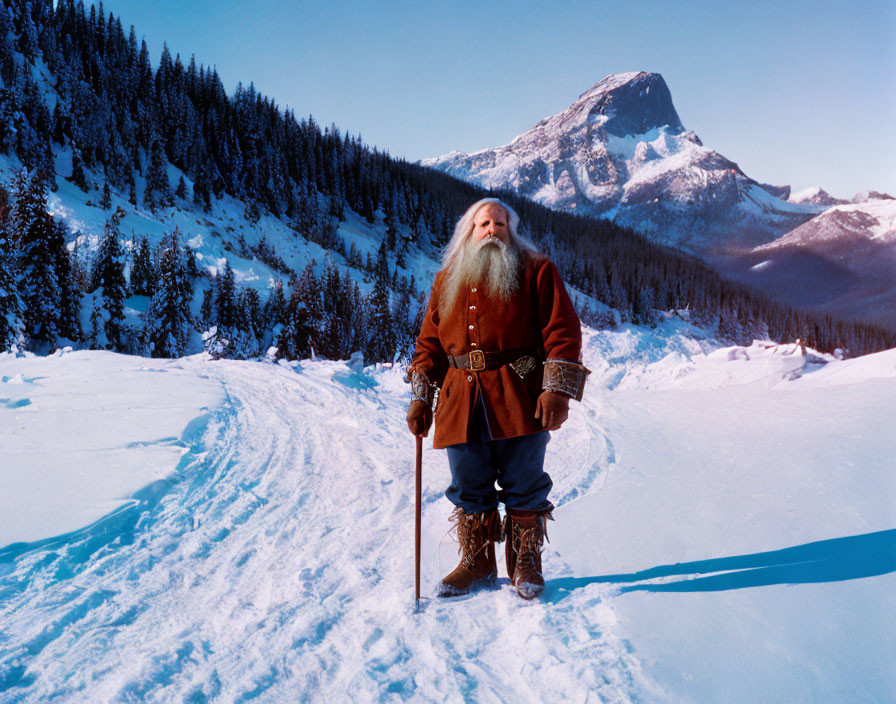 Elderly man in red outfit in snowy mountain landscape