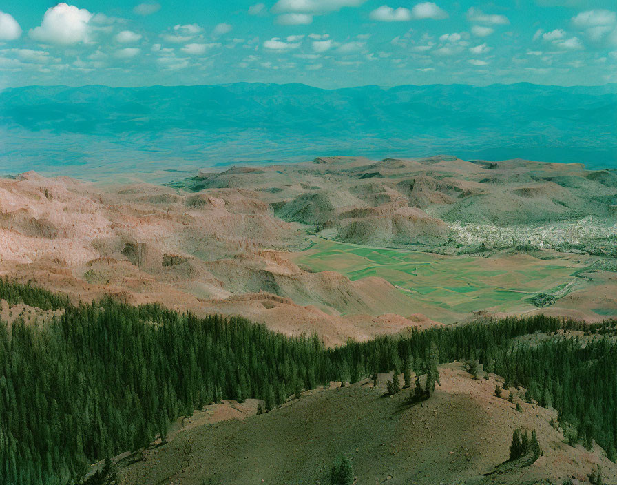 Rugged hills and green fields in a valley under a blue sky