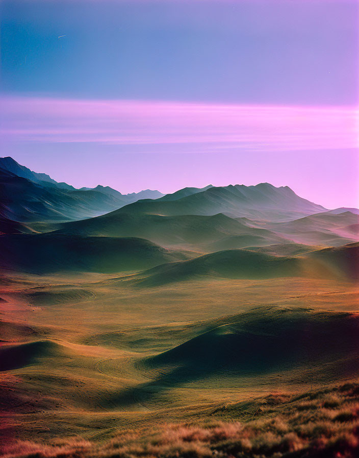 Twilight sky over undulating hills in purple and blue hues