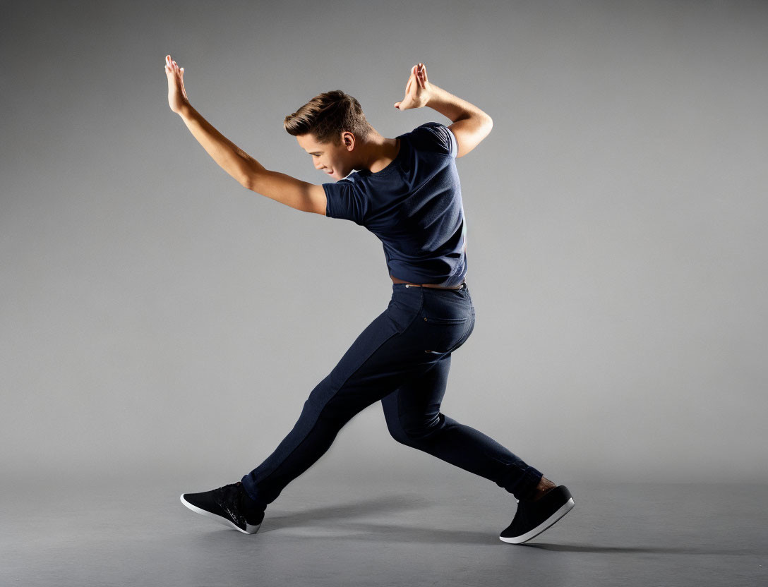 Dynamic Dancer in Dark Clothes Against Grey Background