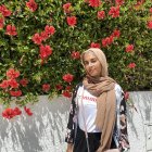 Woman Surrounded by Rose Petals and Flowers Under Clear Sky