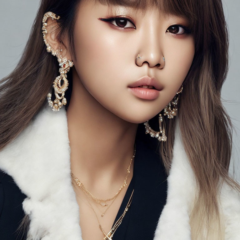 Close-up portrait of person with striking makeup and elaborate accessories on grey background