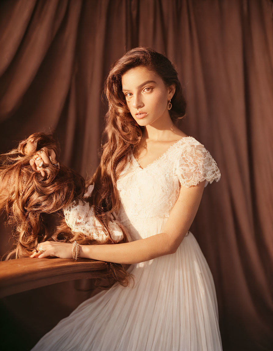 Woman in White Lace Dress with Long Wavy Hair in Warmly Lit Setting