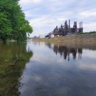 Fantasy castle by calm lake with stepping stones and lush greenery