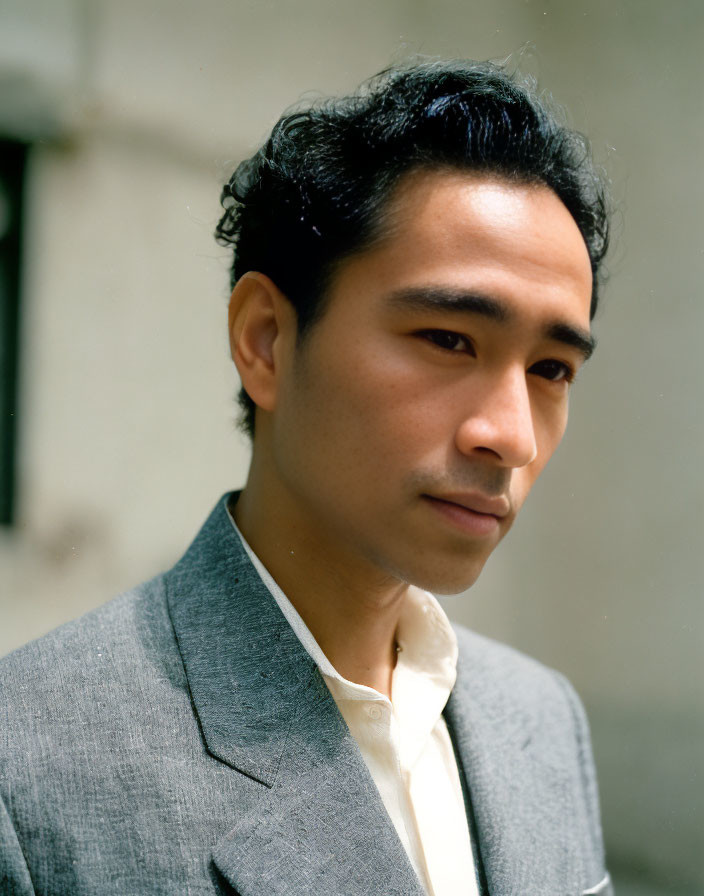 Man with Slicked-Back Hair in Grey Blazer Portrait