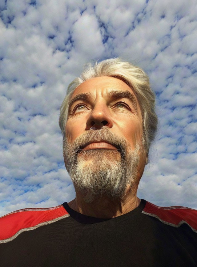 Elderly man with white beard and mustache gazing at sky with clouds