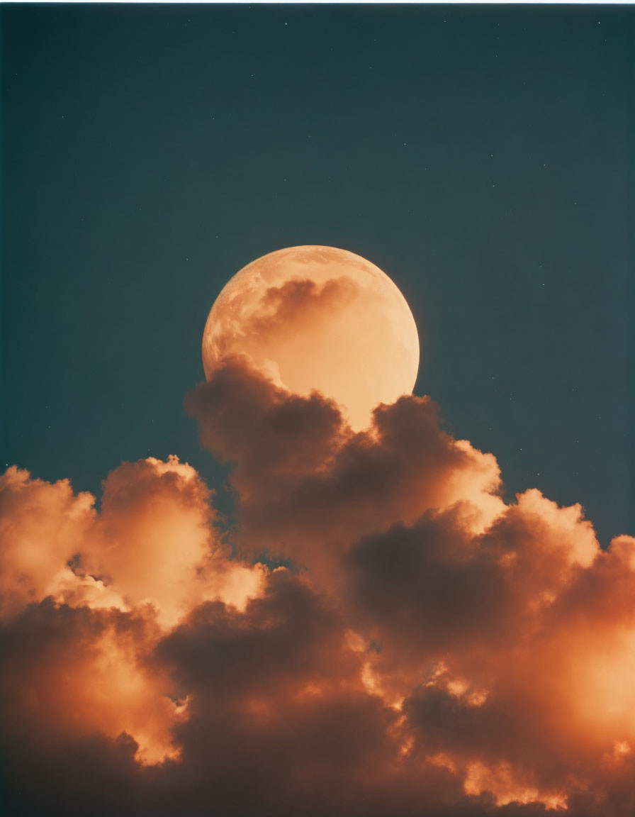 Luminous moon partially obscured by fluffy orange clouds