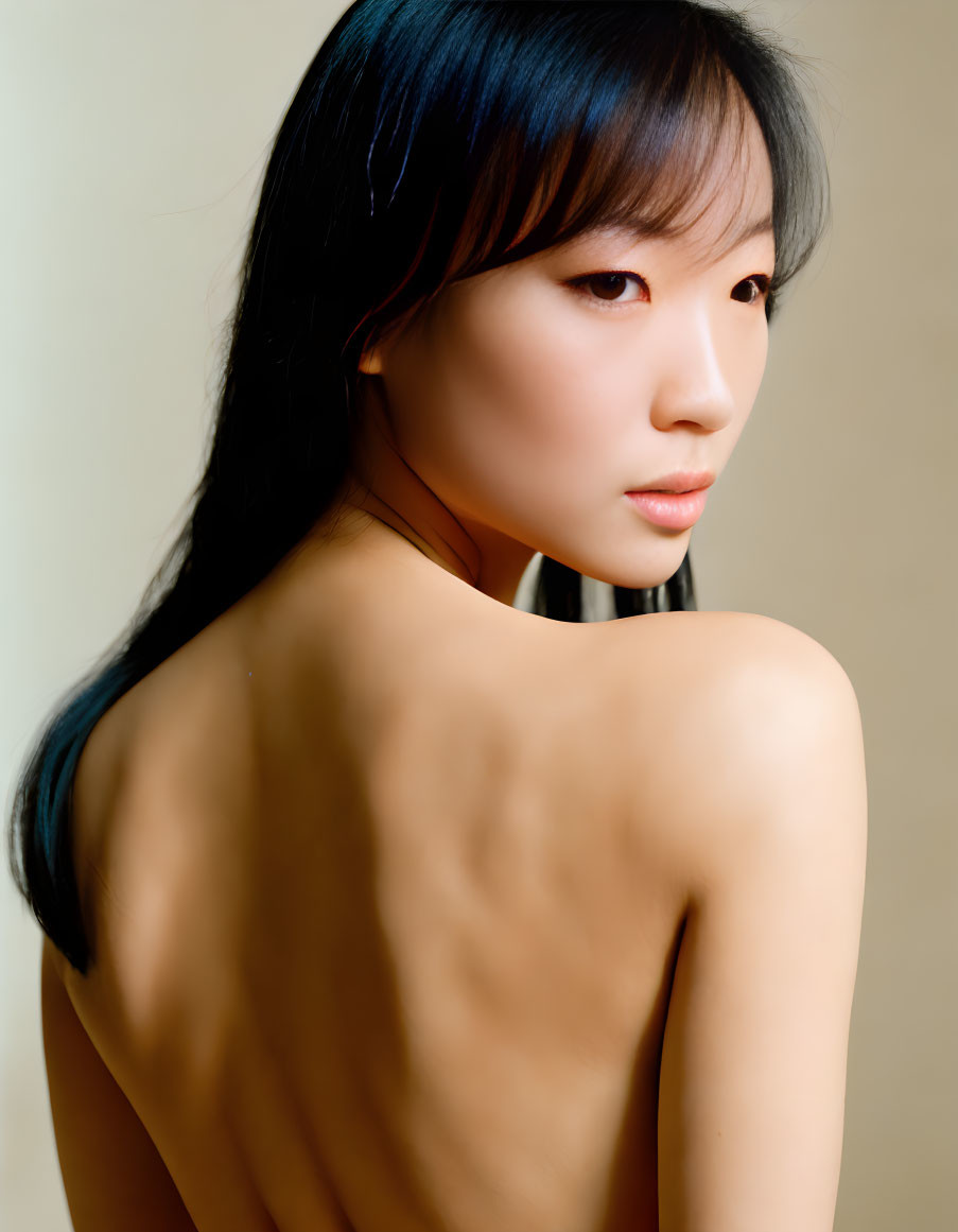 Portrait of woman with bare shoulders, dark hair, gazing aside