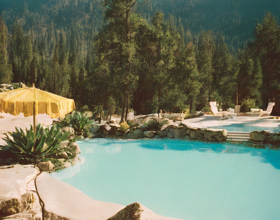 Tranquil outdoor swimming pool with yellow umbrella and sun loungers