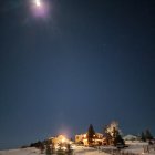 Modern house in desert night with illuminated windows and starry sky