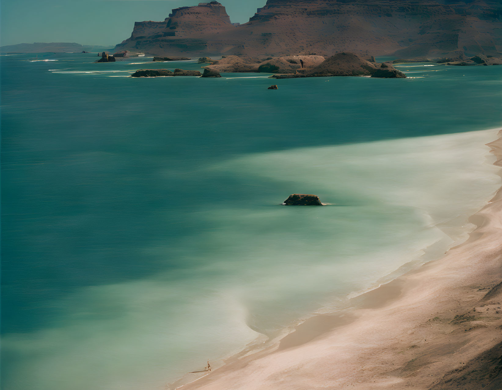 Serene Beach with Turquoise Waters and Rock Island