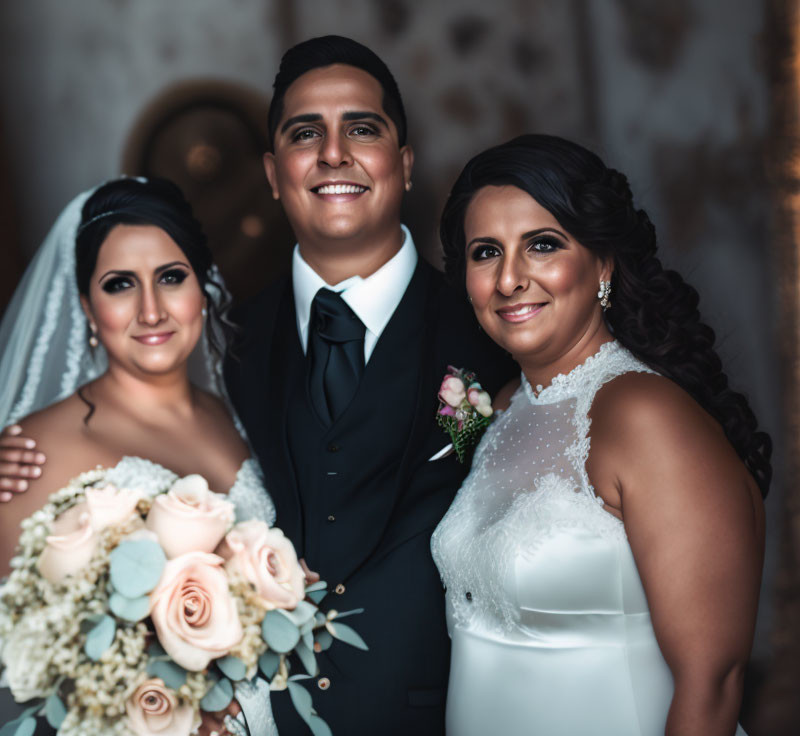 Wedding photo with smiling trio in black and white attire and roses bouquet