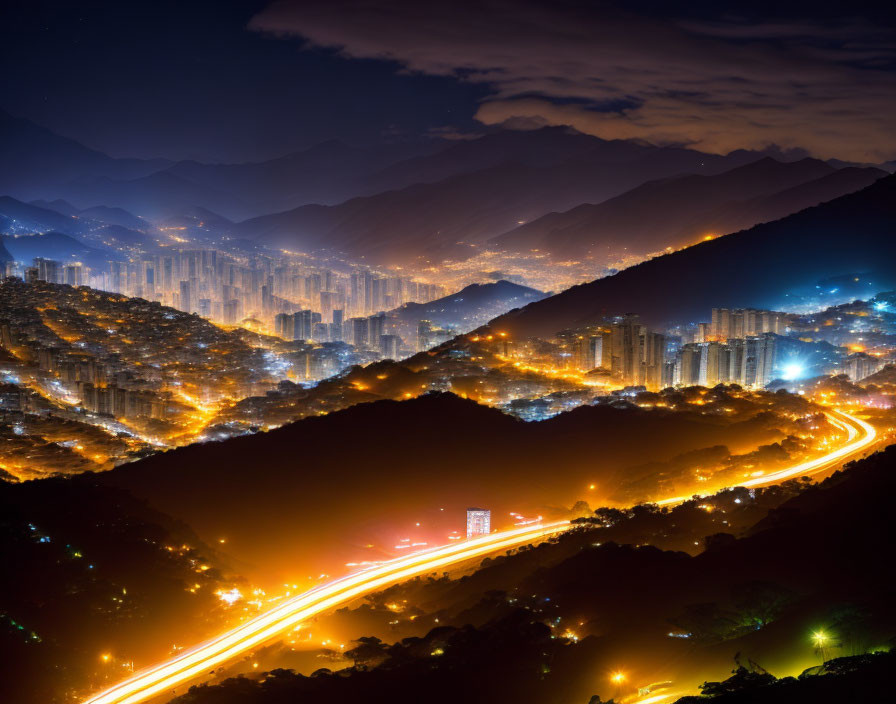 Nighttime cityscape with illuminated high-rises and winding road under starlit sky