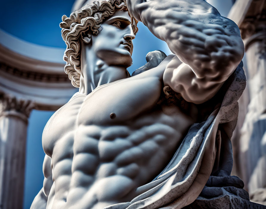 Classical marble sculpture of muscular male figure with flowing hair and draped fabric against architectural backdrop