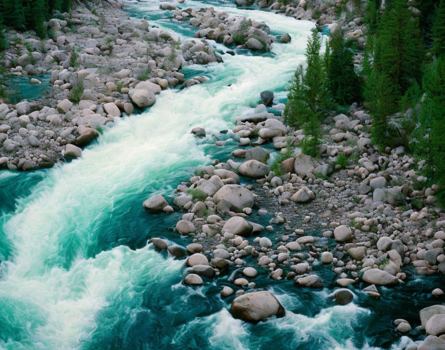 Twilight scene: Turquoise river, rocky landscape, evergreen trees