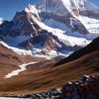 Snow-capped peaks and golden trees in majestic mountain scene