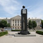 Blue and Gold Clock Tower in Serene Park with White Pillars and Flowers