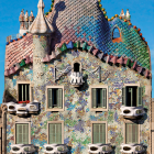 Vibrant three-story house with patterned walls, green roof, balconies, chimney, and