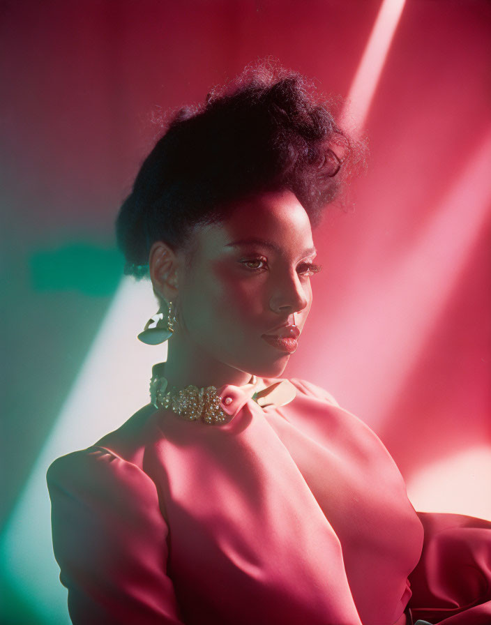 Elegant woman with updo in pink blouse and statement earrings in colorful setting