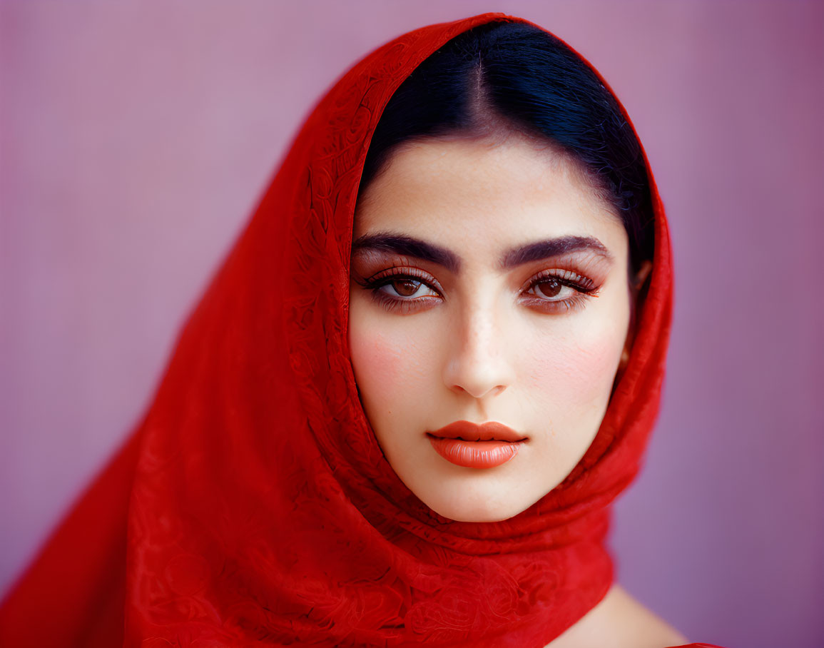 Woman with Striking Makeup and Red Headscarf on Purple Background