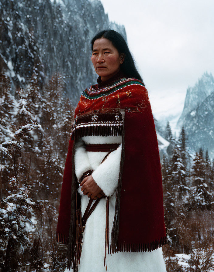 Traditional red and white attire against snowy mountainous backdrop