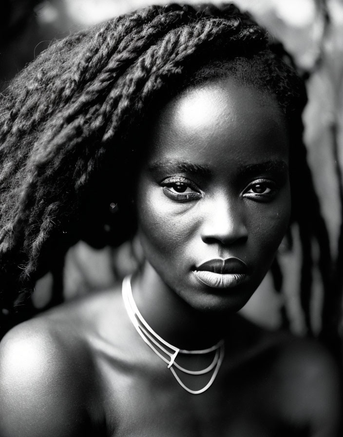 Monochrome portrait of woman with striking eyes and dreadlocks