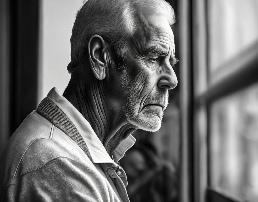 Elderly Man with Beard and Wrinkles Gazing Out Window in Monochrome