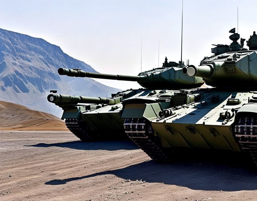 Camouflage military tanks on arid terrain with mountain backdrop