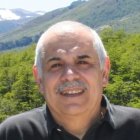 Elderly Man with White Beard and Glasses in Mountain Landscape