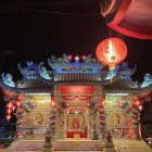 Colorful storefront under starry sky with moon, intricate patterns, and pottery.