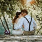 Intimate couple on bridge in vibrant forest with blossoming flowers